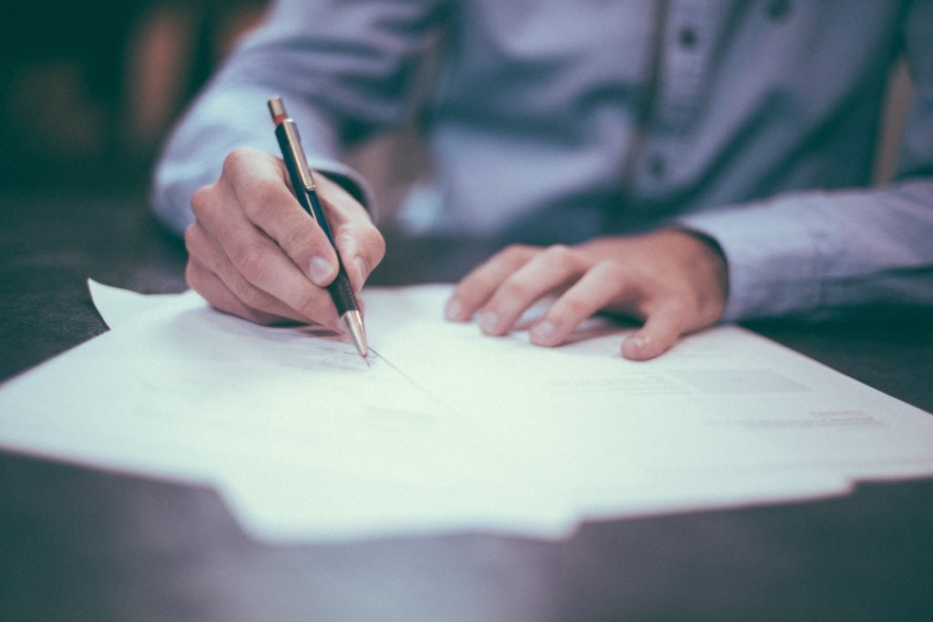 Man writing in a paper. 