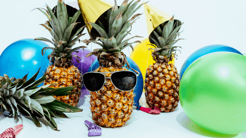 Pineapples decorated with sunglasses and party objects