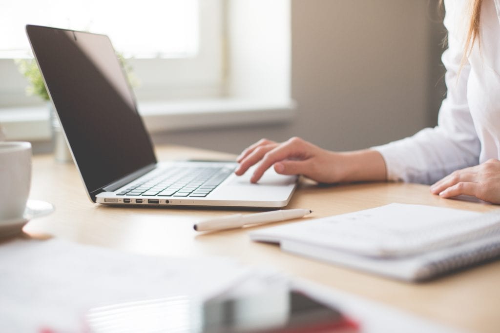 Remote worker writing in laptop 