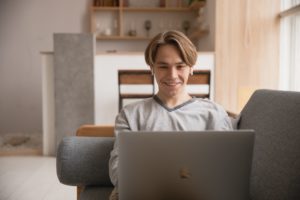 Remote employee smiling at laptop screen