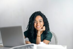 women smiling while working with her computer