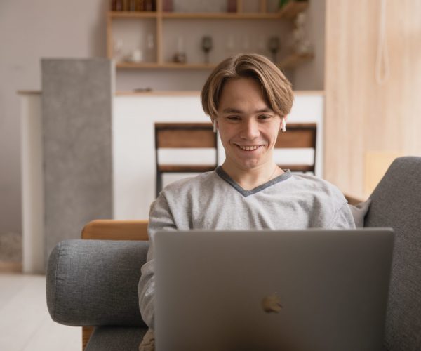 Remote employee smiling at laptop screen